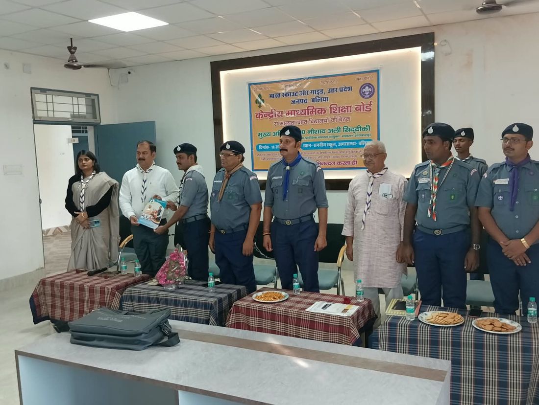 Officers and guests standing at the district meeting of CBSE schools at Sunbeam School Ballia, the Bharat Scouts & Guides banner behind them.
