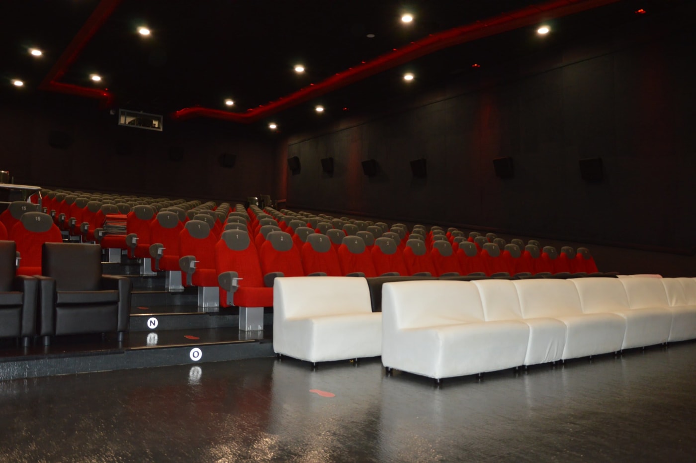 Una sala con i divanetti bianchi davanti alle poltrone numerate