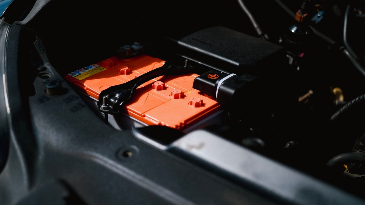 Detailed view of an electric car battery inside a vehicle's engine compartment, highlighting sustainable technology.