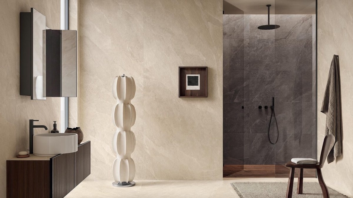 Modern bathroom with stone-look walls, a walk-in glass shower, a floating vanity with a vessel sink, and a sculptural floor l