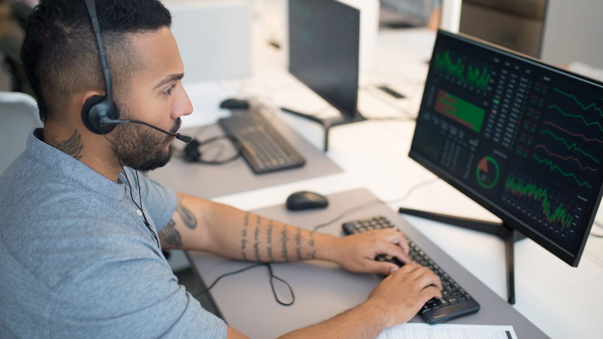 Sony-owned ISP data breach hits 2.6 million users Man in a headset analyzing stock data on a computer monitor at his workspace.