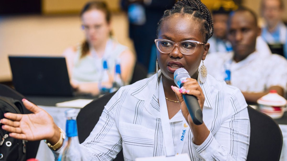 Payment providers urged to broaden services beyond transactions Woman speaking into a microphone during a business conference, engaging with audience.