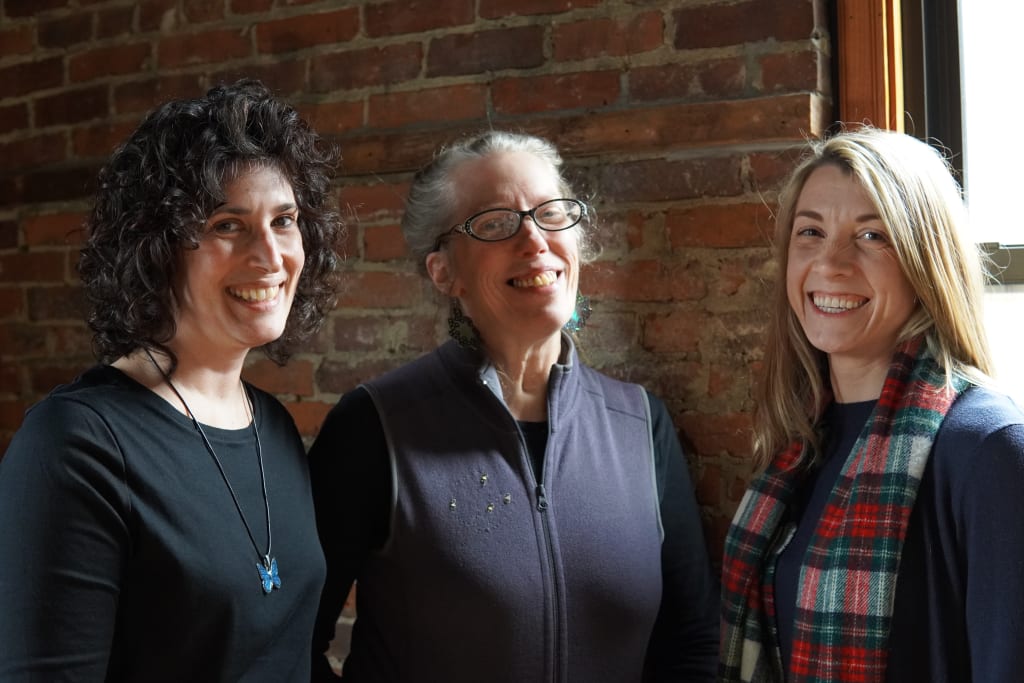three women standing next to each other getting ready for Demo Day