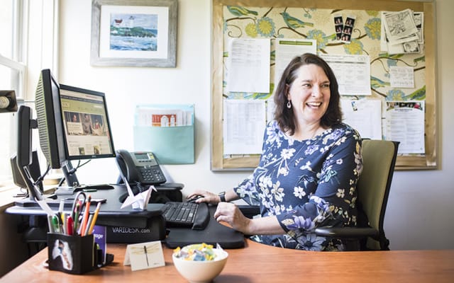 Woman at desk helping students