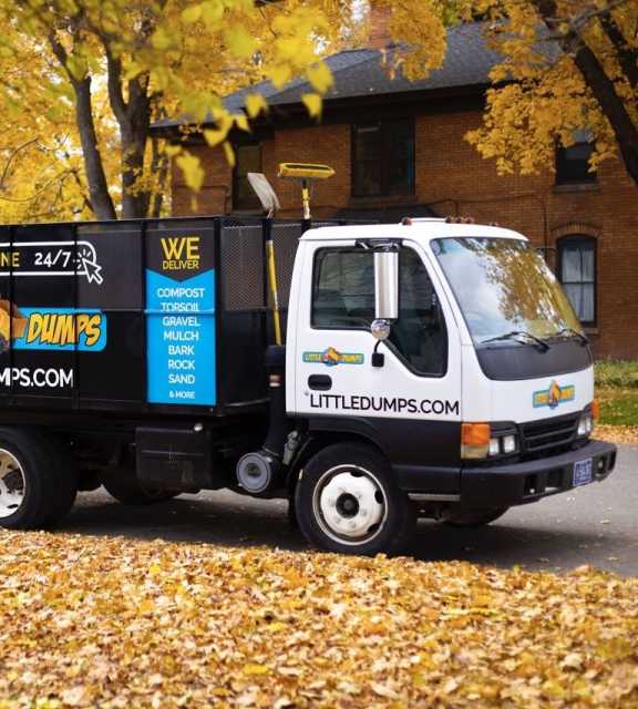 An photo of a Little Dumps dump truck parked under a Missoula tree with fall colors.