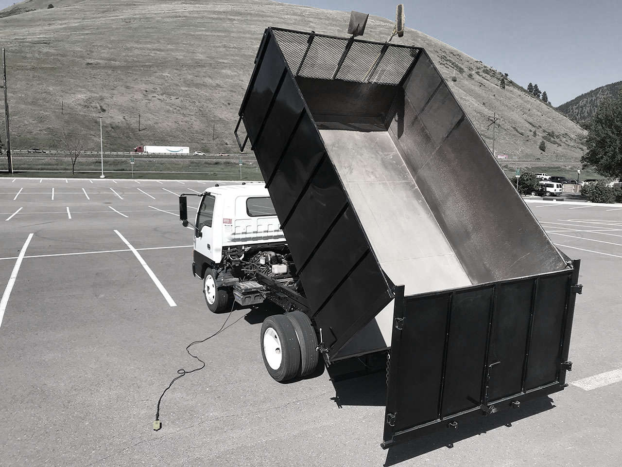 Dump truck with its bed lifted up.