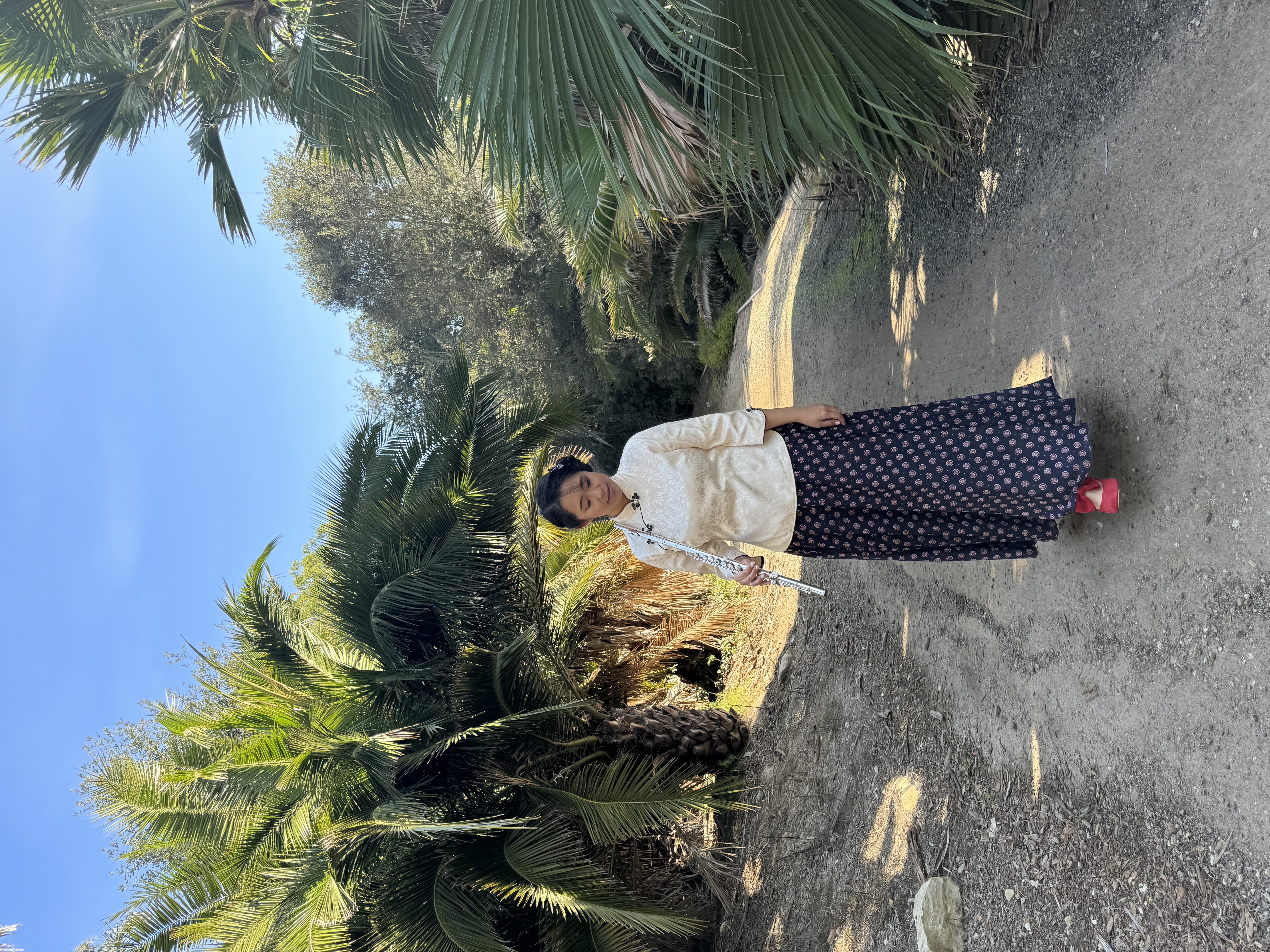 Weili walking through the garden with her flute