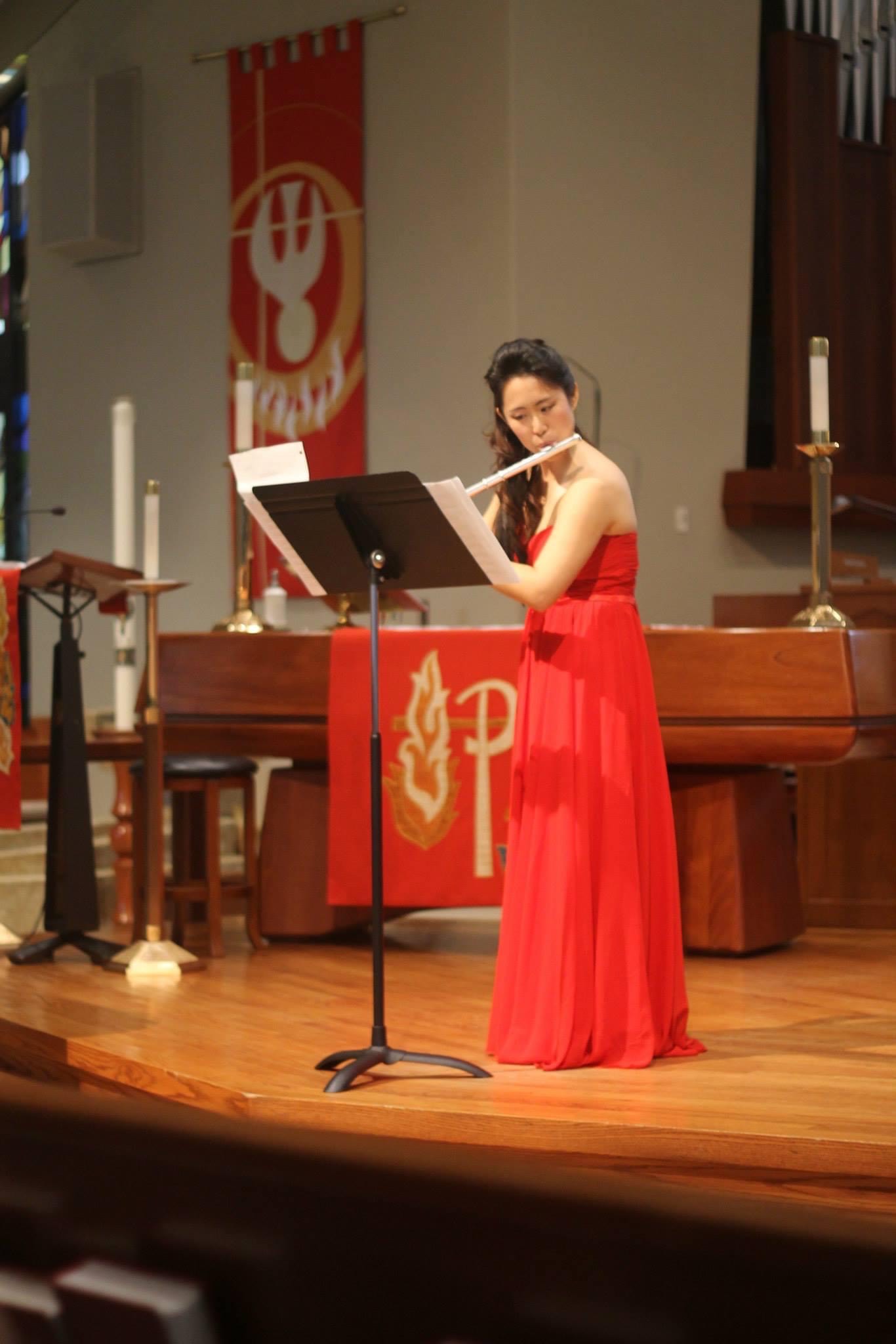 Weili playing the flute on stage