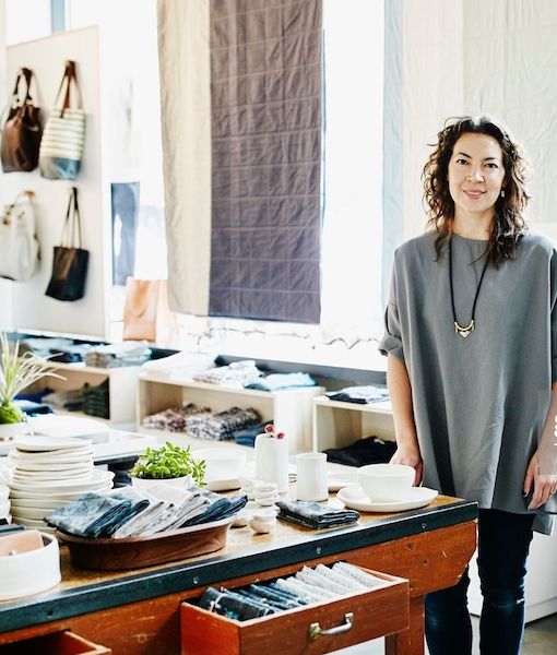 A woman standing in a fashion boutique looking to camera