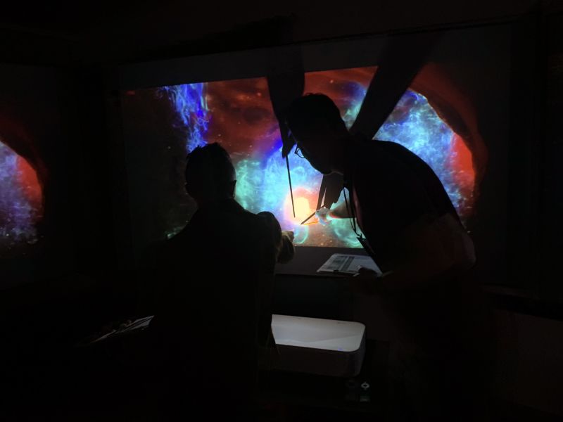 Judges comparing ultra short throw projectors side by side