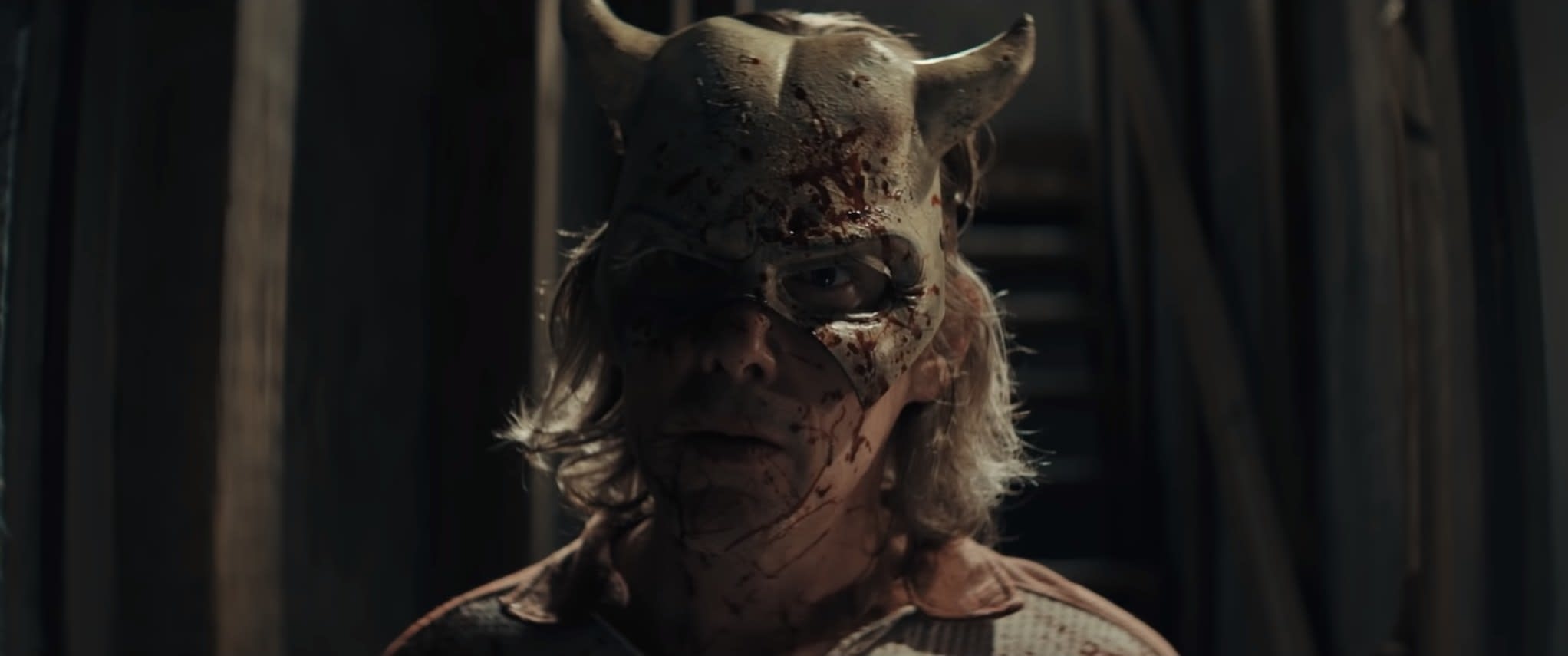 Ethan Hawke in a bloody broken mask with horns in The Black Phone