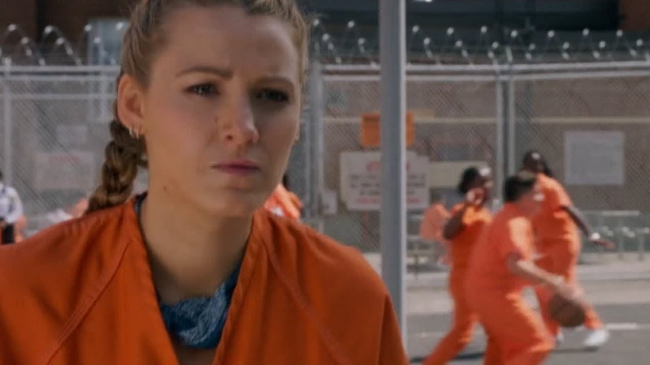 Imagem de uma personagem do filme. Ela está em uma prisão e vestindo roupas de presidiária.