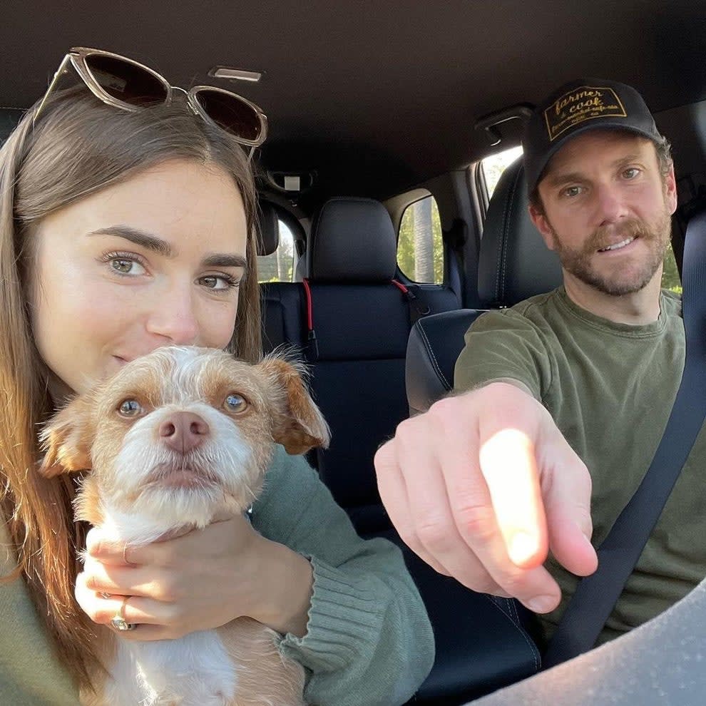 Lily, holding a dog, with Charlie in a car