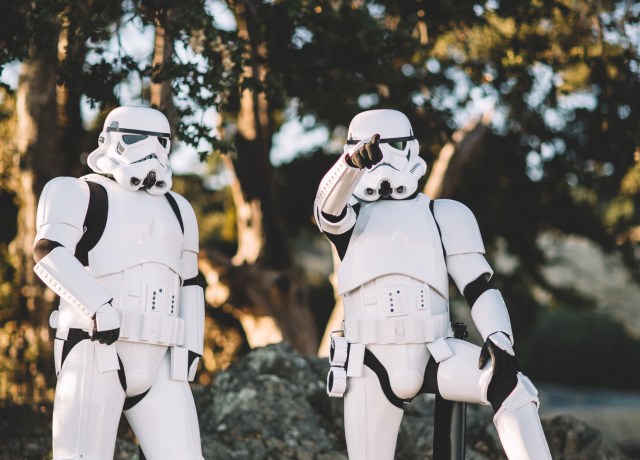 two Star Wars Stormtrooper action figures on gray surface outdoors
