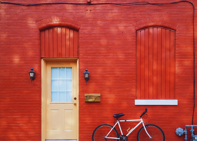 white bicycle parked beside wall