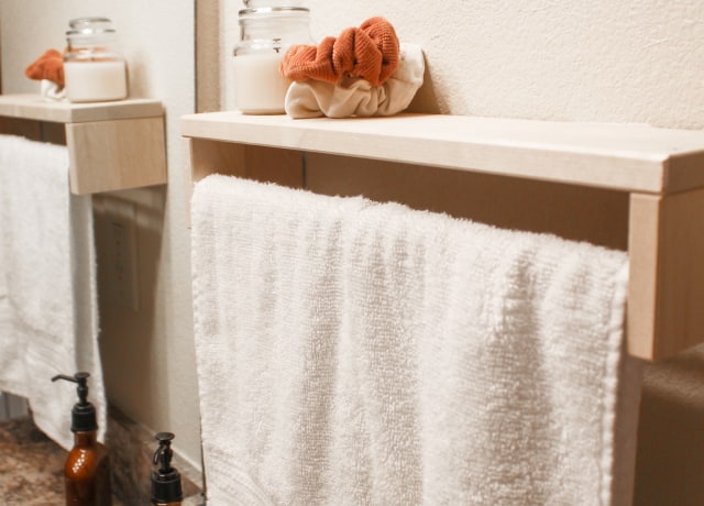 white bath towel on white wooden shelf