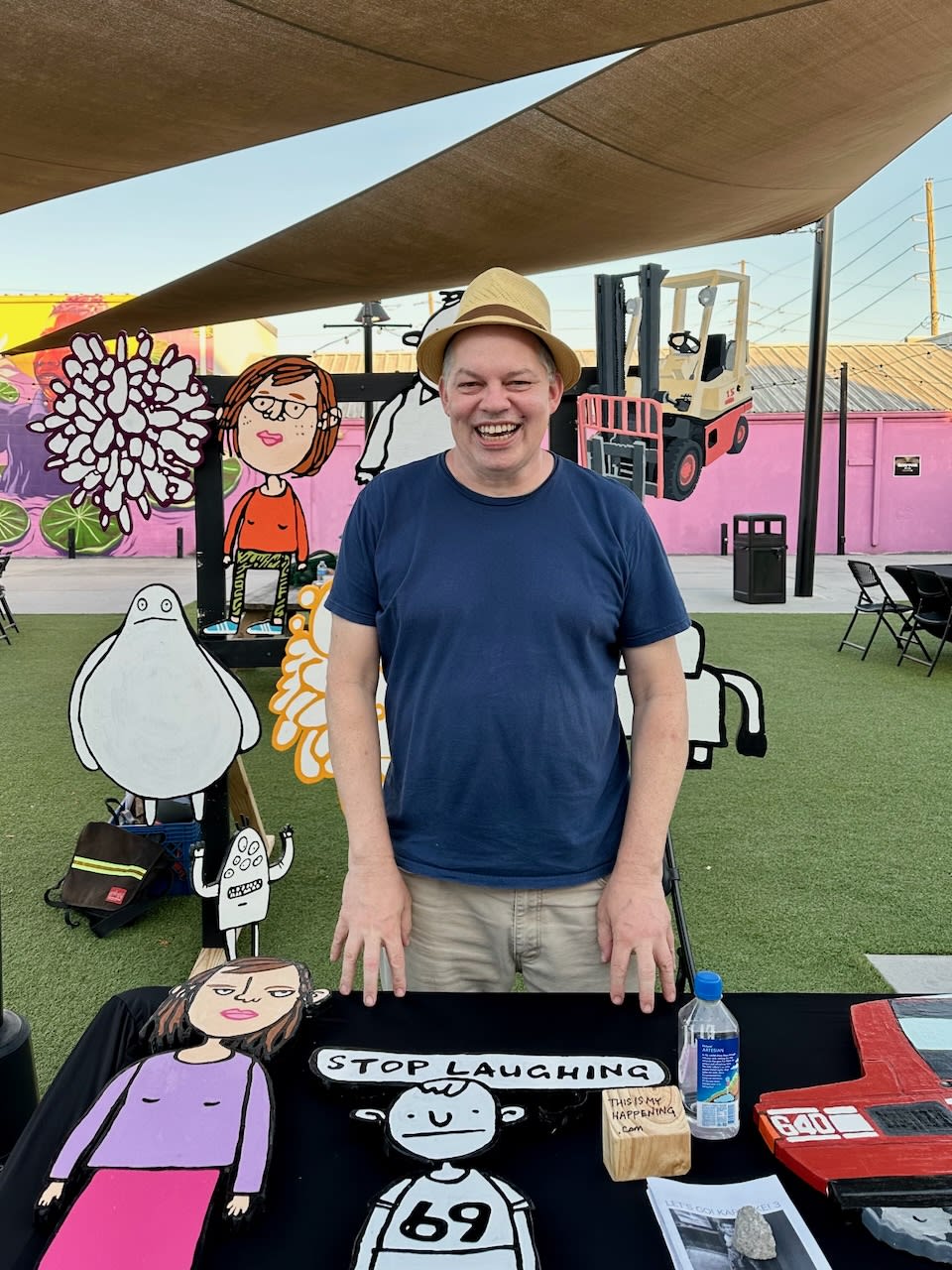 Dave Rhoden looking extremely ill-at-ease but smiling because he's being photographed at an art market