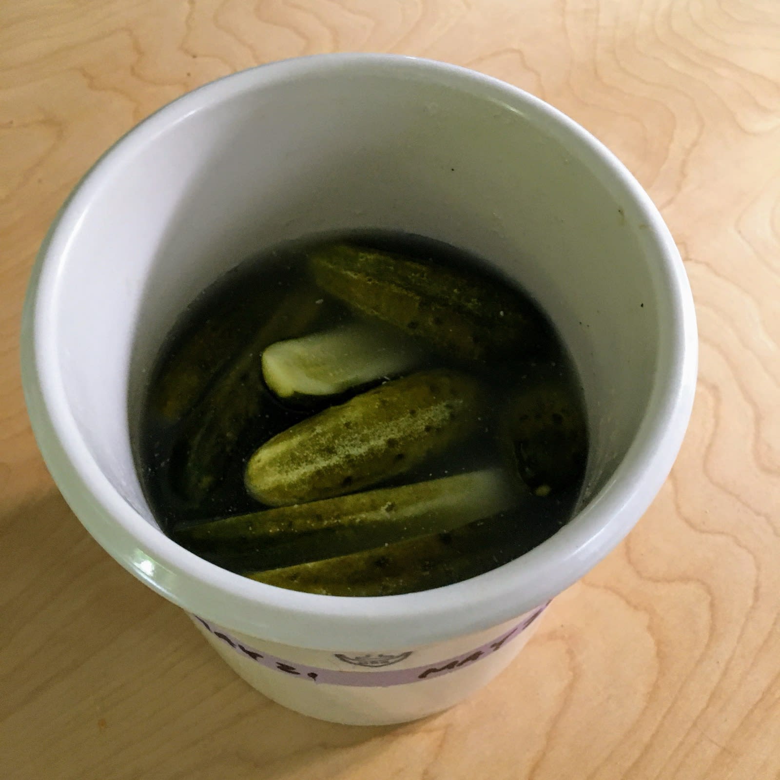 a crock of homemade half-sour pickles a crock of homemade half-sour pickles