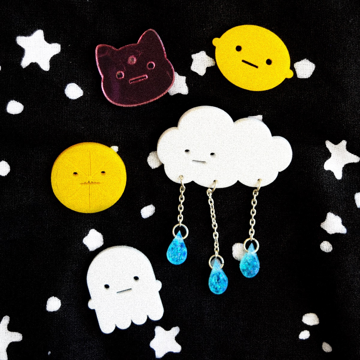 Assortment of Sad Boiz Co pins, including the rainy cloud, three-eyed cat, lemon head, lemon slice, and ghost