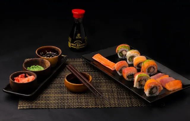 photo of foods served at restaurant,
        sushi platter on one side with soy sauce wita a mix of side dishes