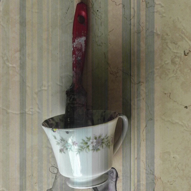 Composición: taza, pintura, brocha, piso