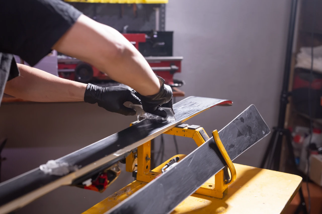 Fartage de la semelle d’un ski de fond en atelier pour améliorer la glisse.
