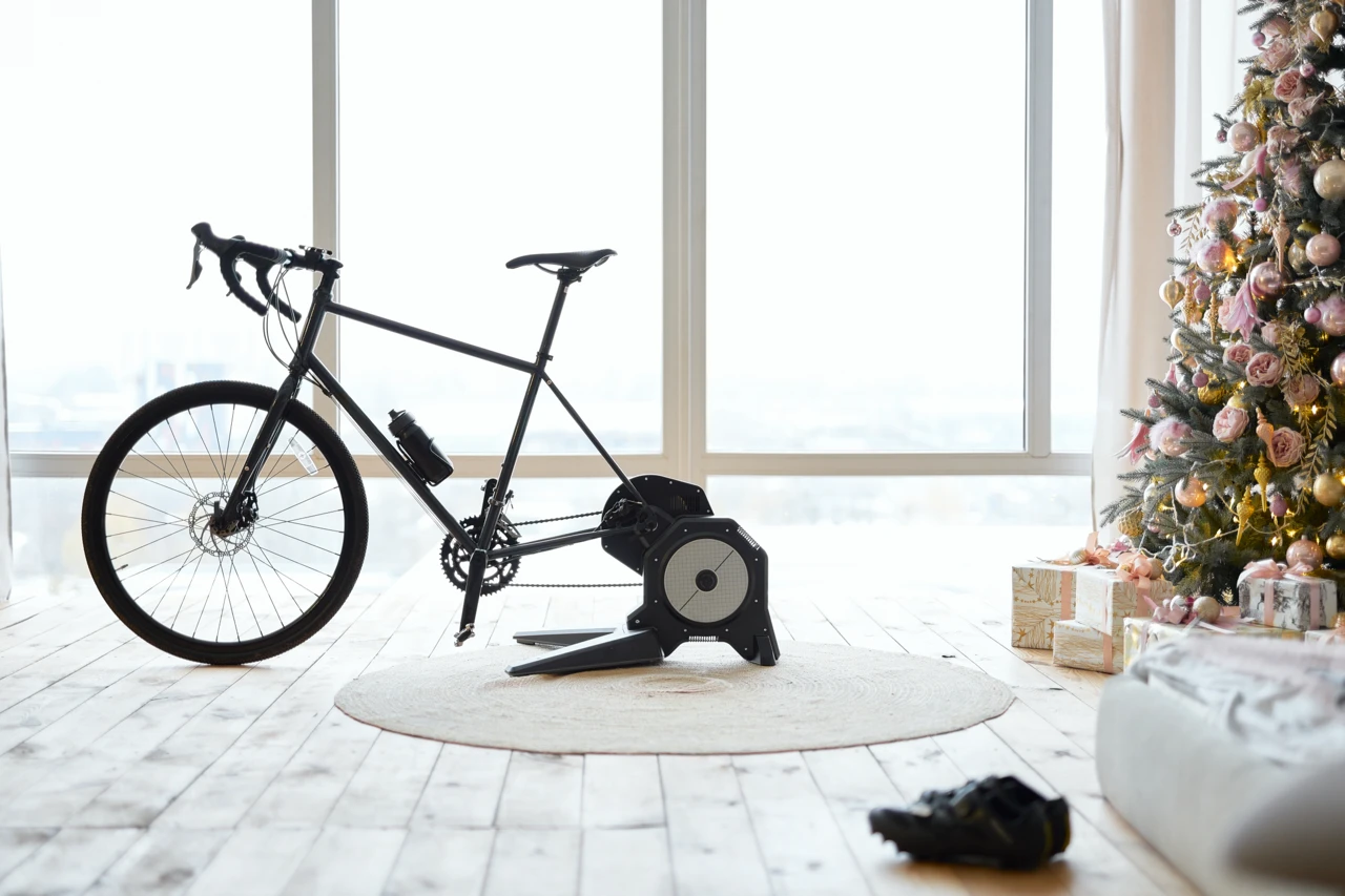 Vélo de route installé sur une base d’entraînement Direct Drive dans un salon.