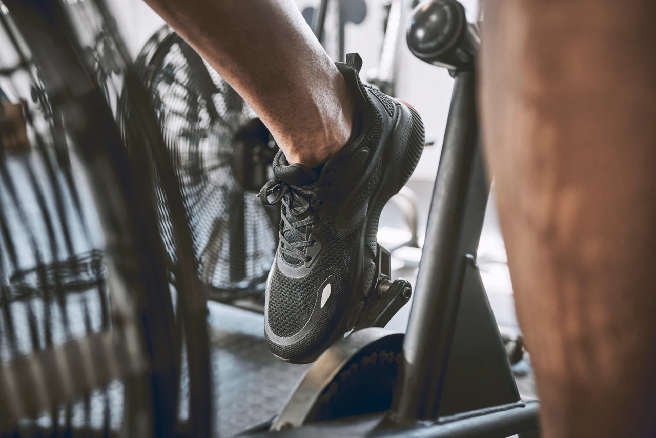 Gros plan d’un pied qui pédale sur un vélo d’entraînement intérieur.