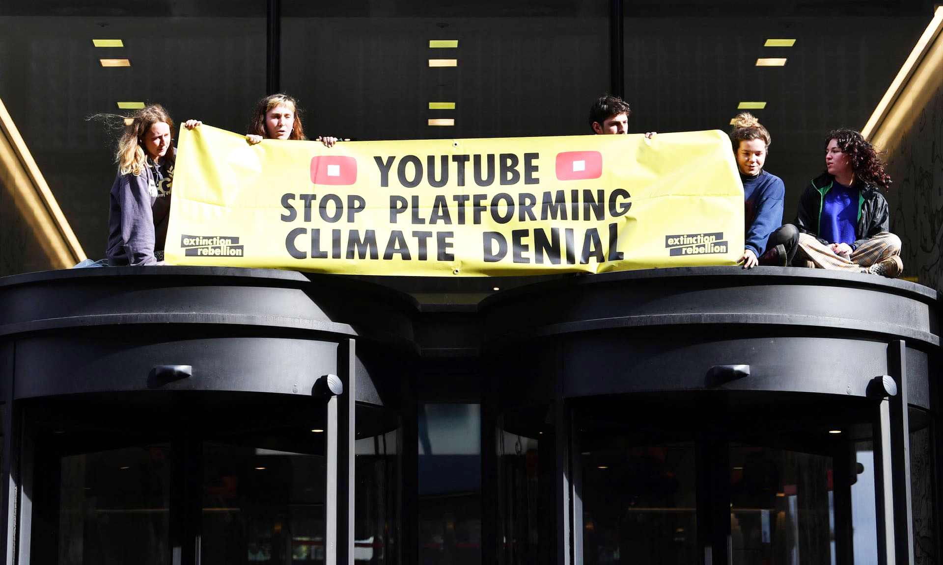 Fiatal klíma-aktivisták a londoni Youtube iroda bejárata tetején. | Fotó: Paul Ellis/... via .... 'Az idősebb generációk nem értik': amikor meghallják az XR ifjúsági tagozatát