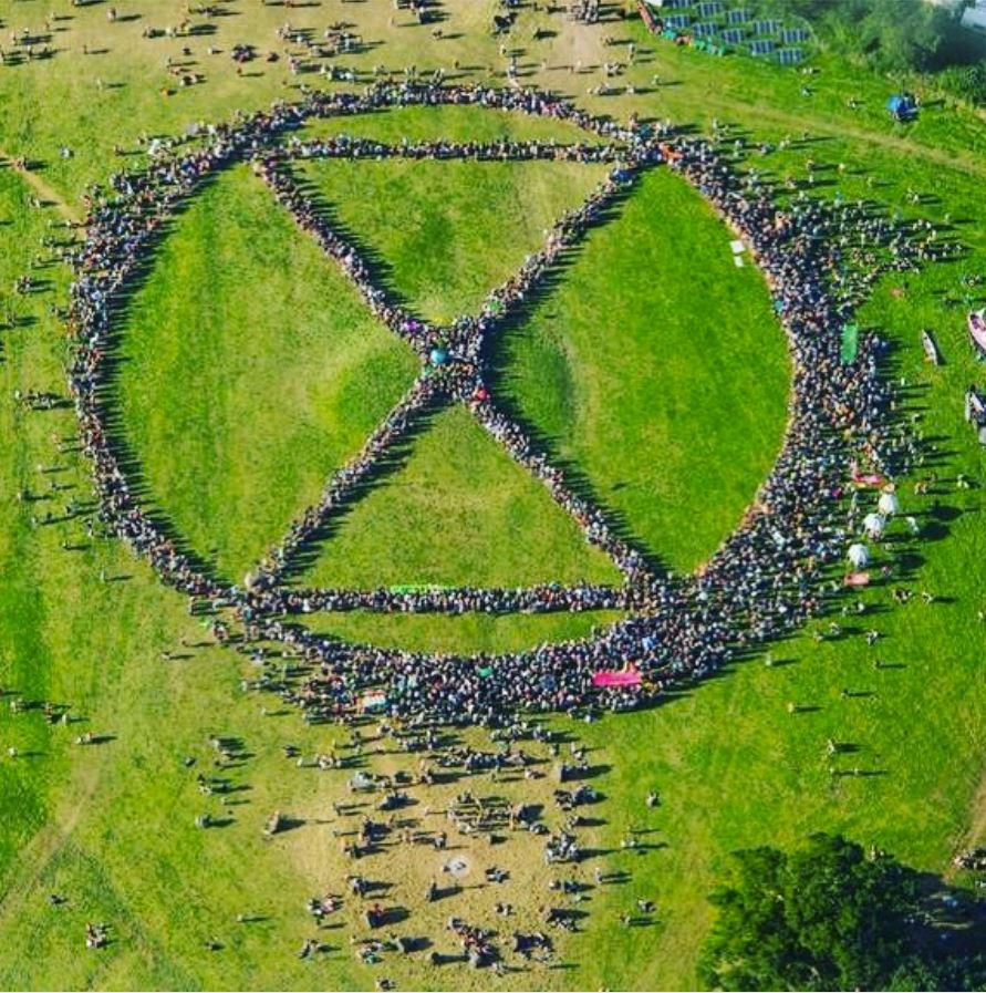 Aktivisták formálják meg az Extinction Rebellion logóját Ha a rendszer emberellenes, akkor az ember legyen rendszerellenes | ClimeNews