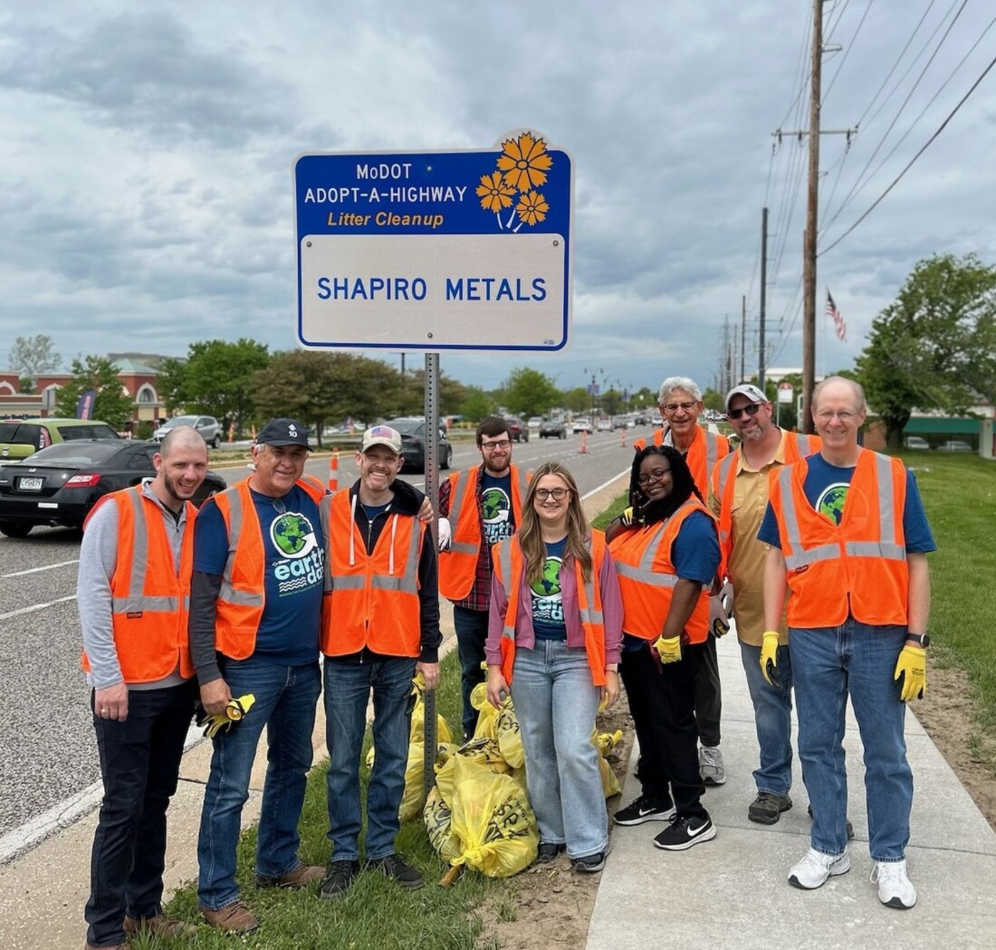 People posing in front of Shapiro litter cleanup sign