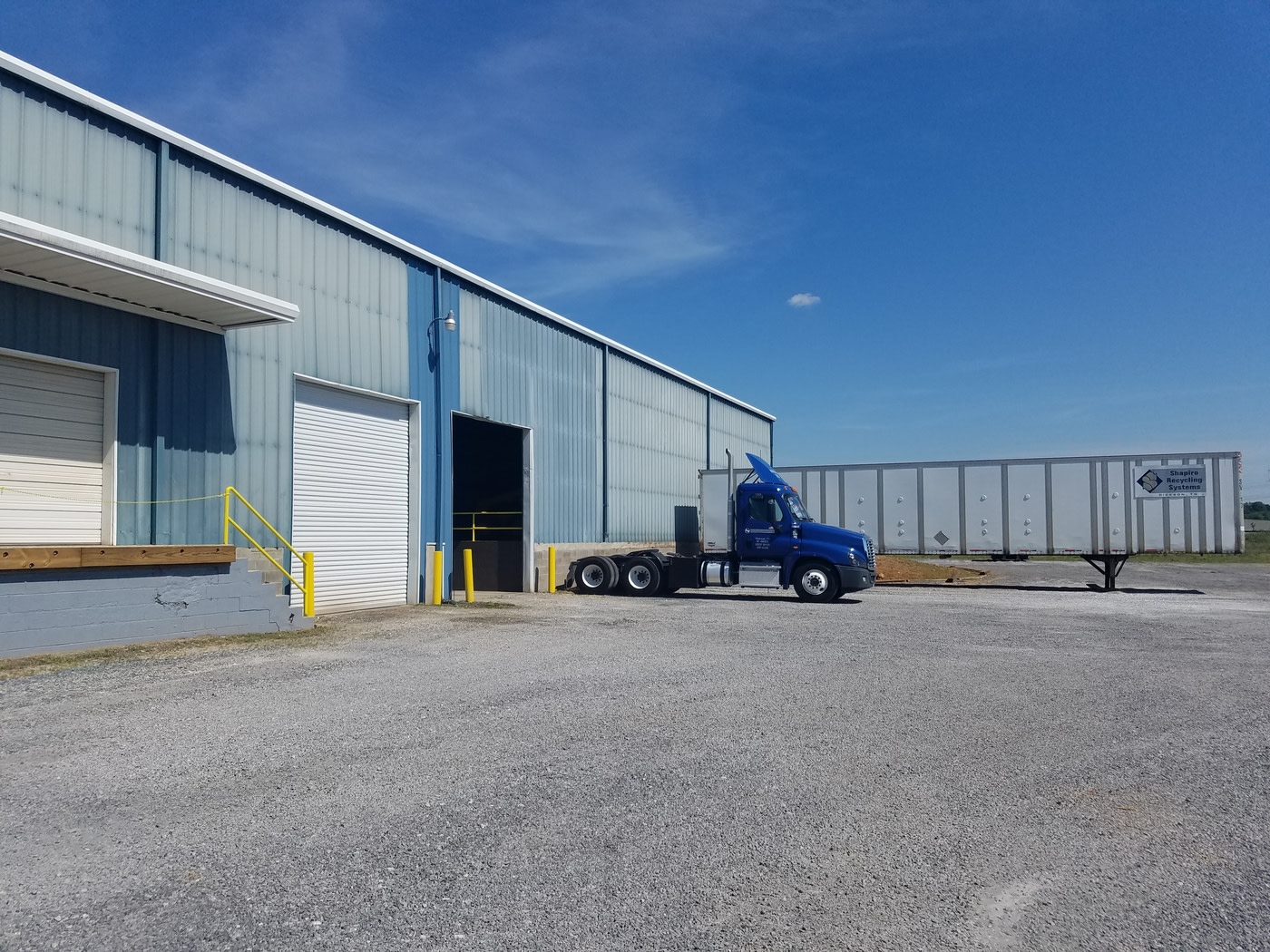 blue 16 wheeler by a garage
