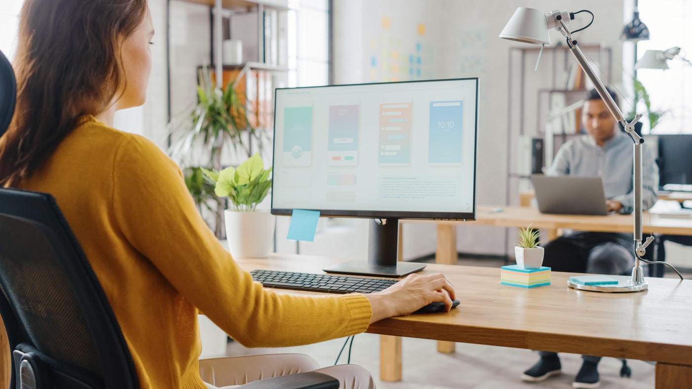Person in a yellow sweater using a computer