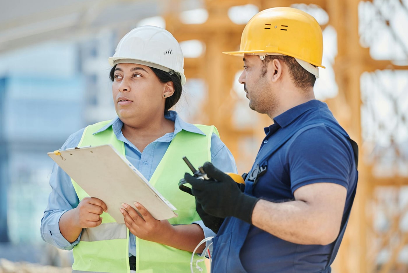 People wearing hard hats in mid-discussion on a work site