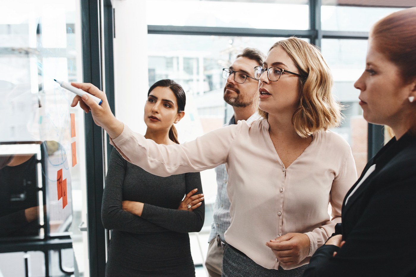 A group standing around a whiteboard brainstorming ideas