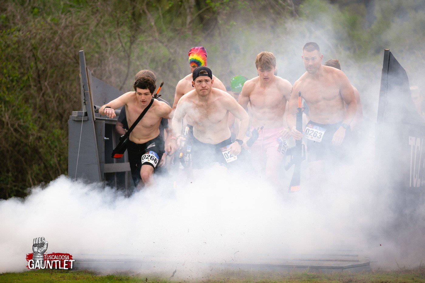 Shirtless men running into smoke
