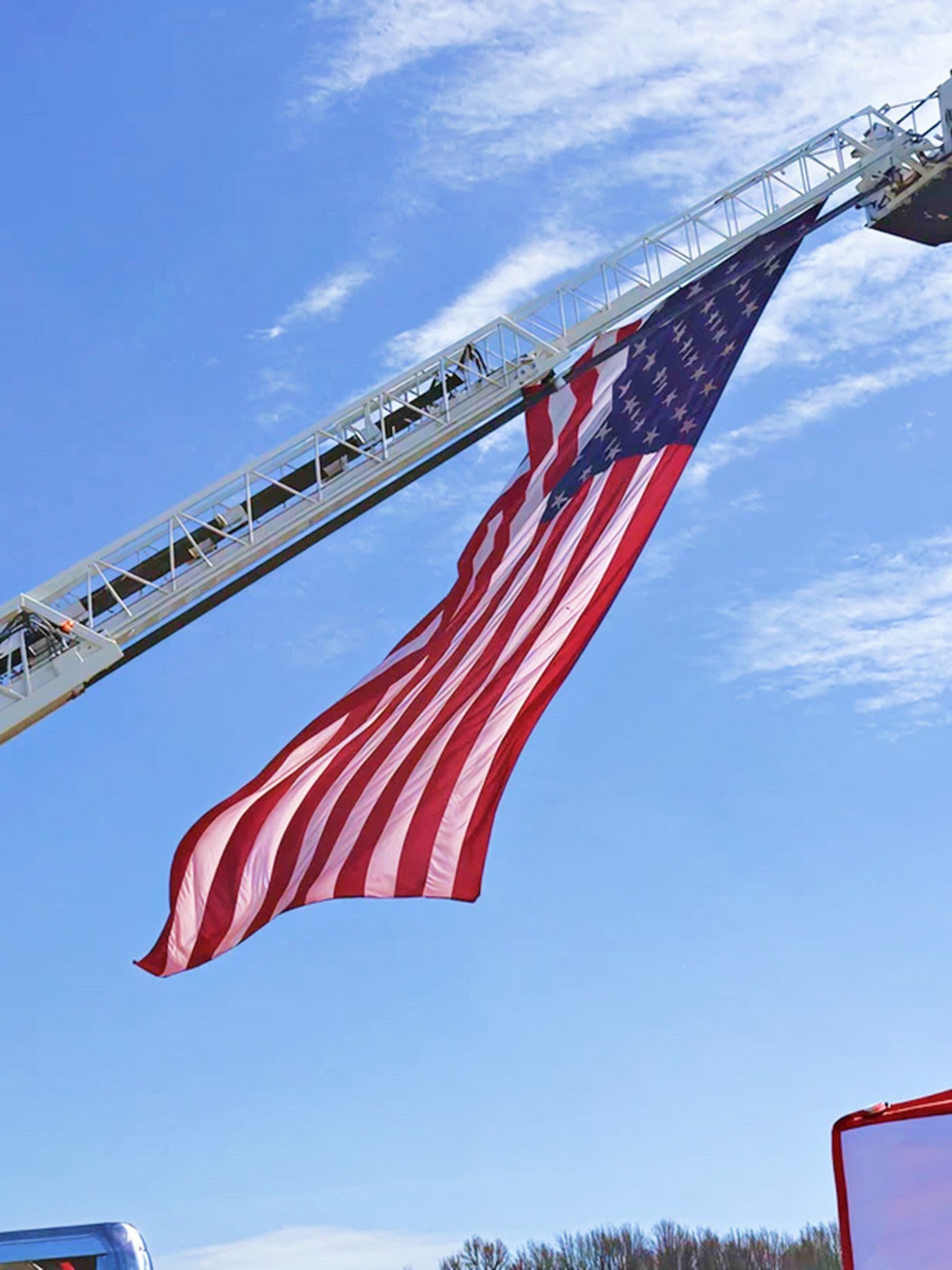 American flag waving from a fire truck ladder