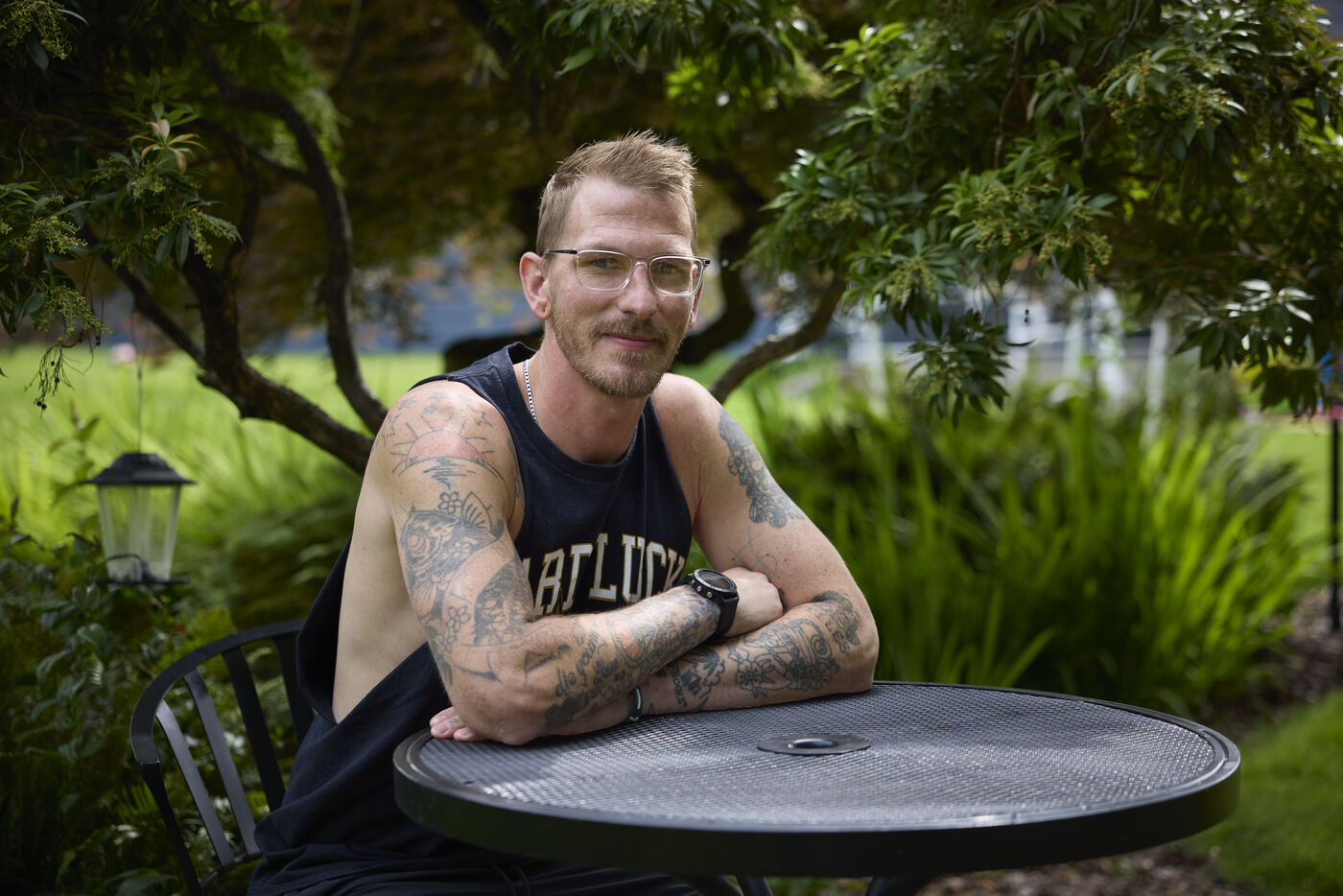  Man sitting at a table outside with his arms crossed 