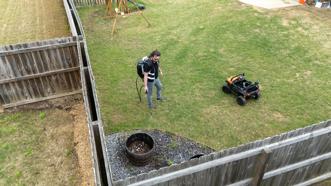 Man spraying chemicals on a backyard