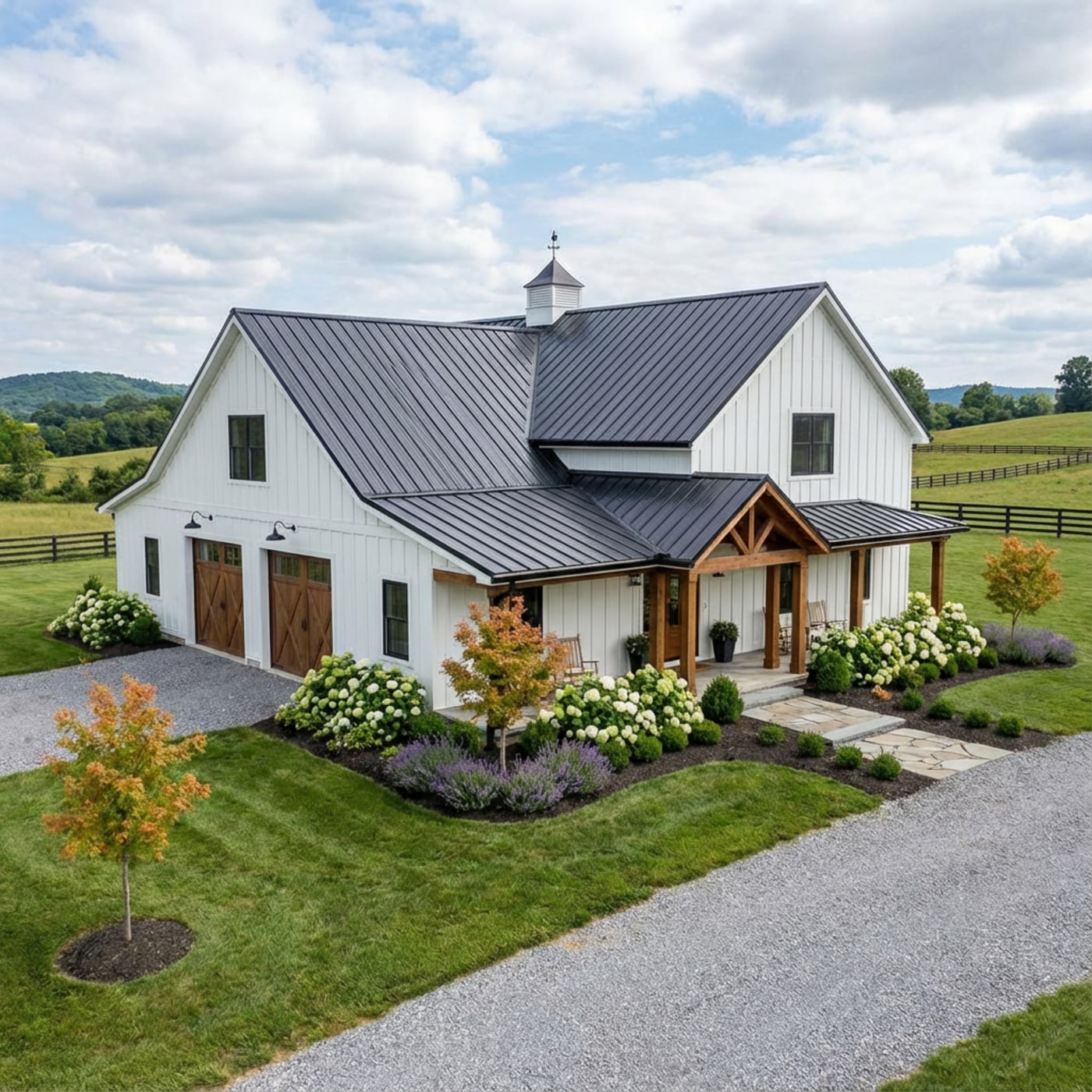 White board-and-batten farmhouse with dark metal roof, timber porch, and landscaped gardens in rural setting.