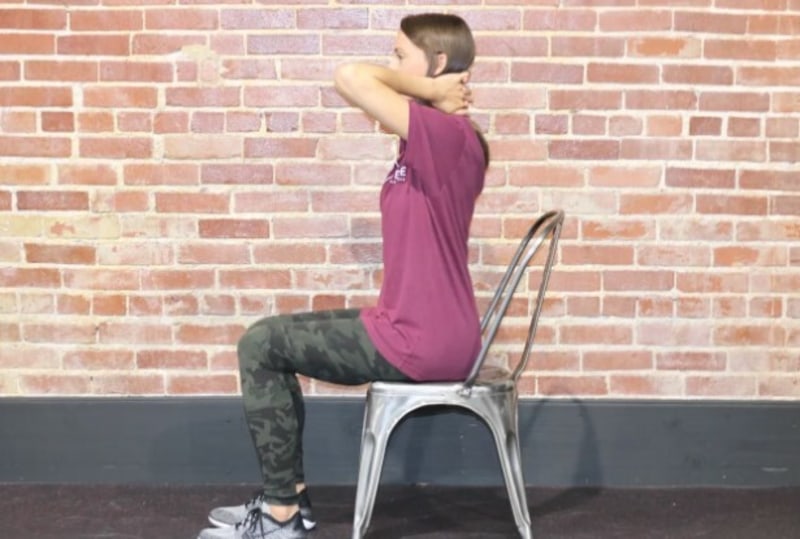 Woman sitting in a chair with her fingers crossed and hands behind her head