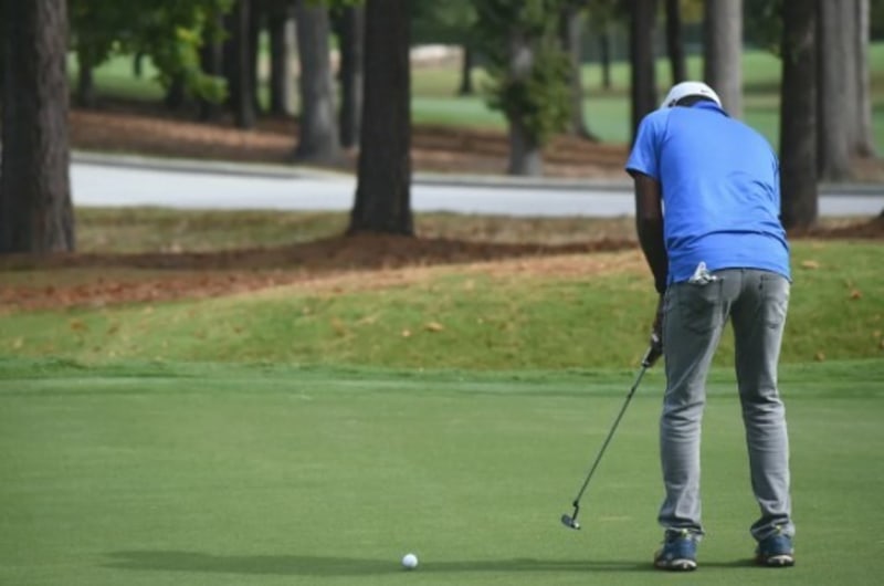 Golfer in blue shirt on golf course