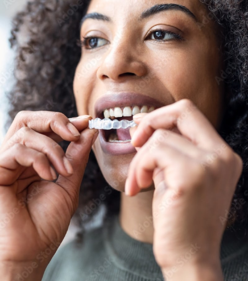smiling girl holding Invisalign