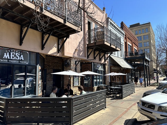 Sidewalk view of a downtown Tuscaloosa street with sidewalk cafes