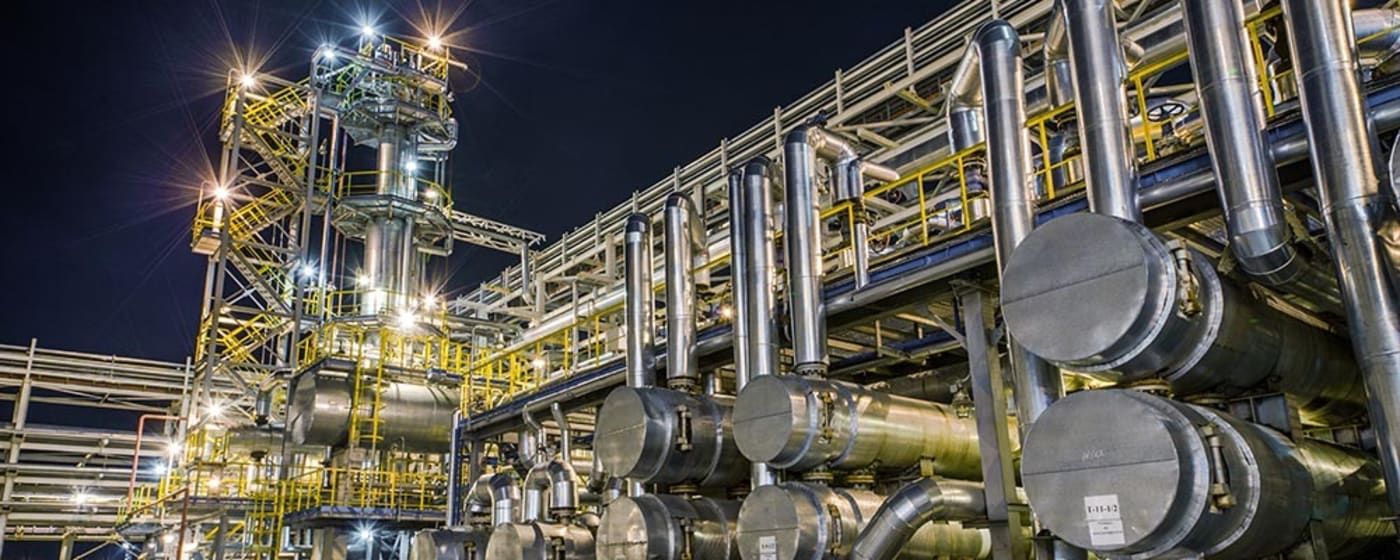 People working on pipes outside of a plant