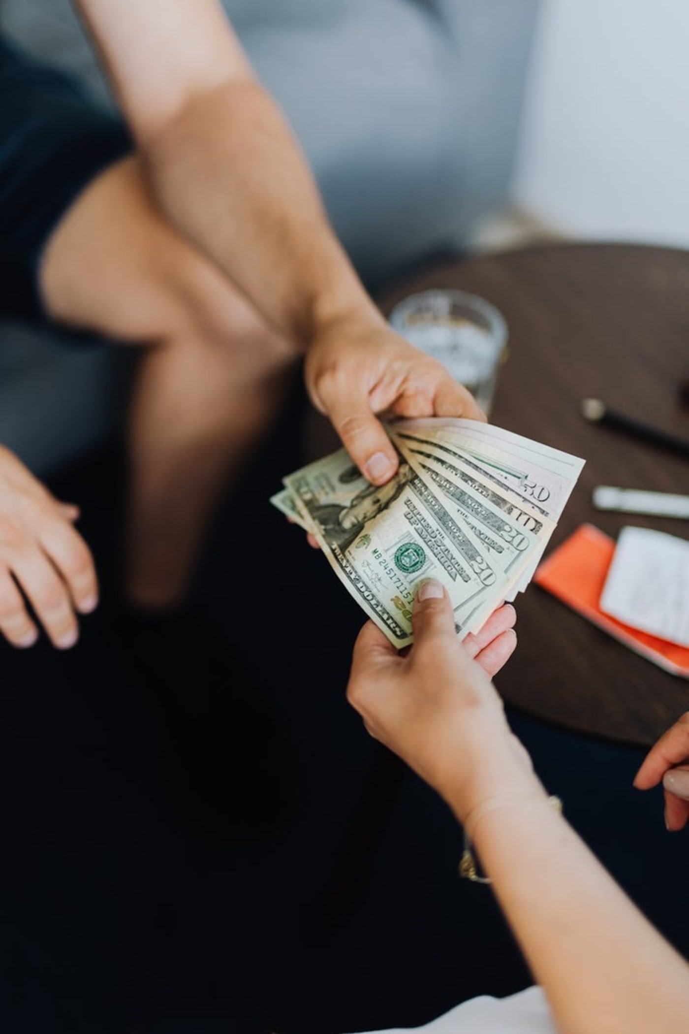 Person handing another person cash money