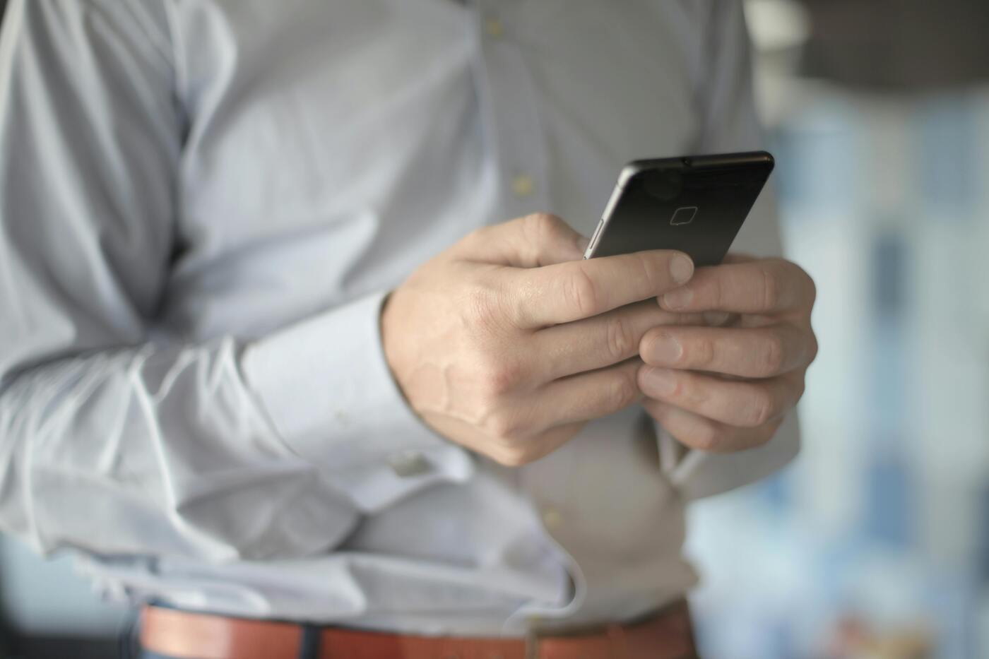 Closeup of a man's hands holding a cell phone