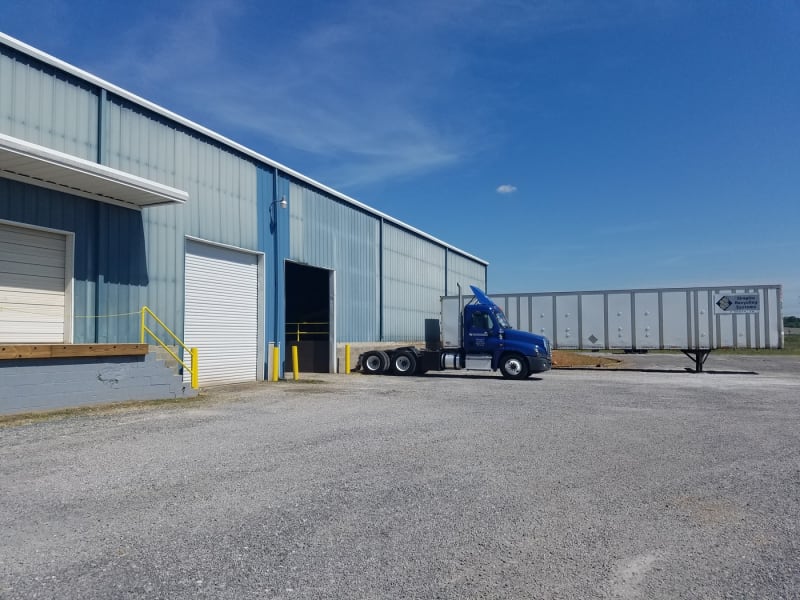 blue 16 wheeler by a garage