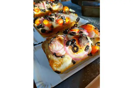 Focaccia masa madre,con toques de aceitunas,cebolla y tomates,formato molde de aprox 500 gr.