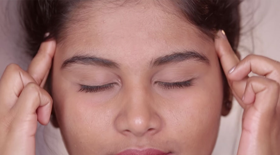 With the help of two fingers, gently press the temple of your head and slowly move from left to right in circular motion.